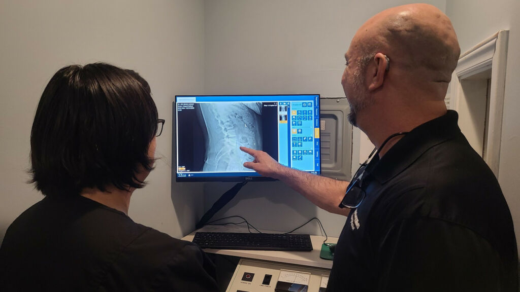 Dr. Michael Elliott show a client their x-rays - How Chiropractors Correct Sciatica